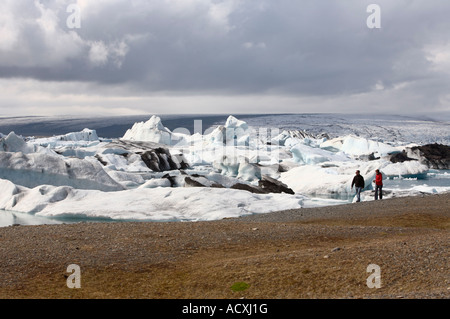 Due persone a piedi la spiaggia di Jokulsarlon laguna glaciale, ghiacciaio Vatnajokull in Islanda Foto Stock