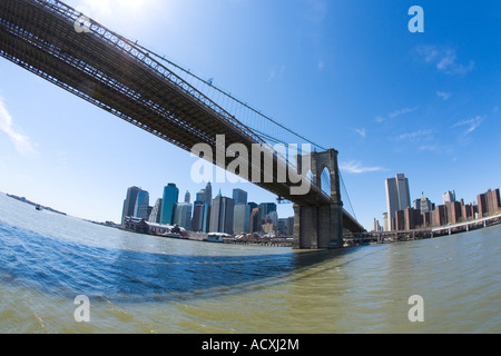 Il Ponte di Brooklyn e la parte inferiore di Manhattan skyline del centro nel sole di primavera sole con cielo blu guardando da Brooklyn verso South St Foto Stock