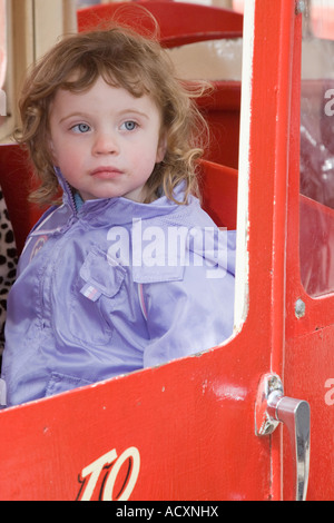 Un giovane bambino su un merry-go-round Foto Stock