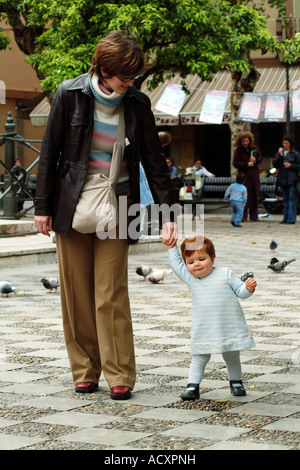 Baby girl tenendo i suoi primi passi con l'aiuto di sua madre, Spagna Foto Stock
