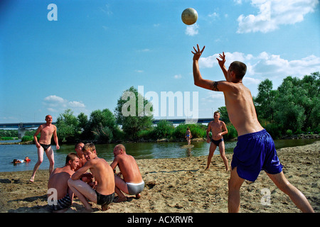 Giovani uomini giocando a pallavolo sulla spiaggia presso il fiume Vistola, Polonia Foto Stock