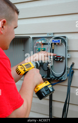 Installazione di TV via cavo e DSL linee e linee telefoniche su casa nuova Foto Stock