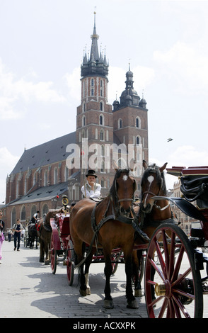 Scena di strada presso la piazza principale del mercato di fronte St Marys Basilica, Cracow Polonia Foto Stock