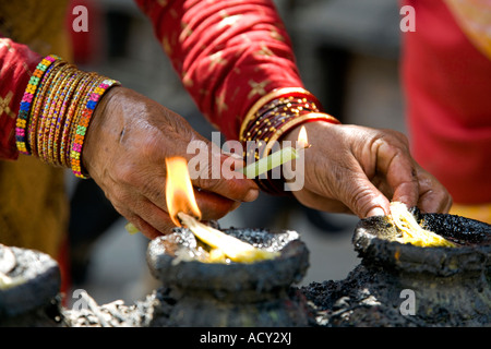 Il nepalese donna illuminazione di lampade a burro.Swayambhunath Stupa.Kathmandu.Nepal Foto Stock