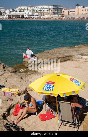 I turisti sulle rocce vicino al San Sebastian castello di Cadiz, Spagna Foto Stock
