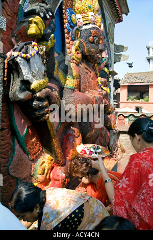 Donne che fanno un offerta di Kala Bhairab. Durbar Square. Kathmandu. Il Nepal Foto Stock