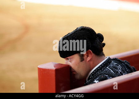 Torero assistente guardando una corrida da dietro il burladero (barriera), Spagna Foto Stock