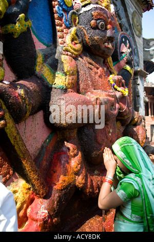 Donna adorare Kala Bhairab dio.Durbar Square.Kathmandu.Nepal Foto Stock