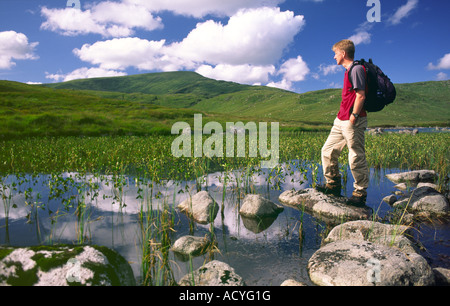 Estate passeggiate in collina nel Galloway Forest Park walker a Loch Neldricken con Merrick e nuvole dietro Galloway Scotland Regno Unito Foto Stock