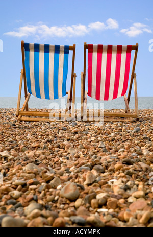 Due sedie a sdraio sulla spiaggia di ghiaia prospettiva bassa Foto Stock