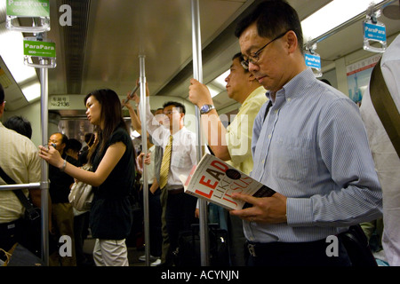 Uomo legge portano come Gesù sul metro di Shanghai a transito rapido sistema di metropolitana di Shanghai in Cina Foto Stock