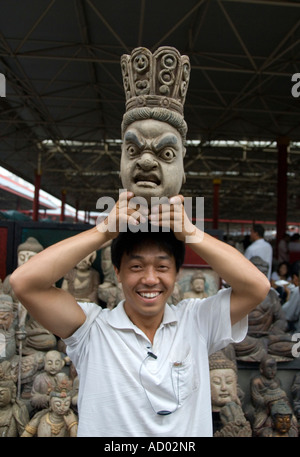 Uomo con legno scolpito a testa Panjiayuan mercatino di antiquariato noto anche come mercato di sporco a Pechino 2007 Foto Stock