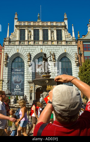 Turistica prendendo una foto della statua di Nettuno e Artus Court lungo Dlugi Targ nel centro di Danzica Polonia Europa Foto Stock