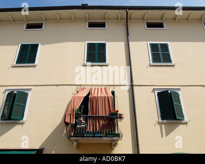 Donna che cerca di fuggire dal sole cocente sul suo balcone a Lazise Veneto Italia Foto Stock