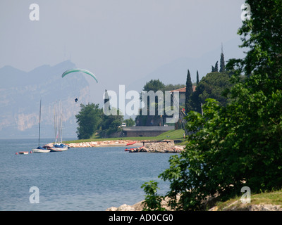 Di atterraggio di parapendio vicino a Malcesine Lago di Garda Italia con il lago e le montagne sullo sfondo Foto Stock