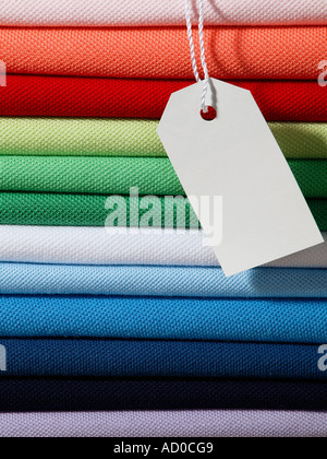 Pila pila di cotone pique poloshirts mens in vari colori con etichetta vuota appeso davanti Foto Stock