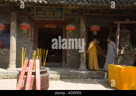 Un tempio monaco e bastoncini di incenso che brucia a Tempio Shaolin Kung Fu luogo di nascita di arti marziali Shaolin nella provincia di Henan in Cina Foto Stock
