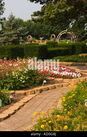 ILLINOIS Arcola mattone percorso attraverso letti di fiori a Giardini Rockome piante di fioritura e strutture di roccia Foto Stock