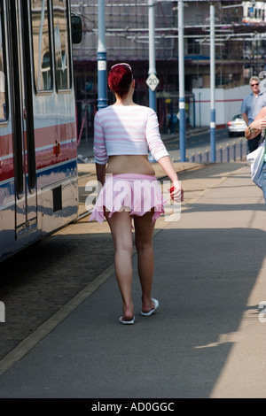Giovane donna in minigonna a piedi oltre il ponte sulla strada commerciale Sheffield Foto Stock