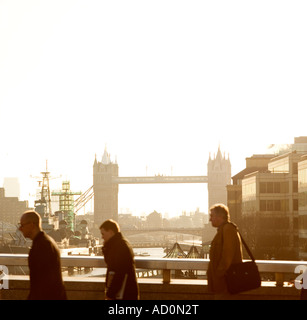 Andare al lavoro la mattina presto a chi lavora in ufficio camminando su London Bridge Tower bridge sull orizzonte Foto Stock