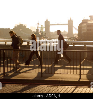 Andare al lavoro la mattina presto a chi lavora in ufficio camminando su London Bridge Tower bridge sull'orizzonte 2007 Foto Stock