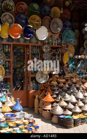 Numerose vetrate luminosamente ciotole, piatti e gli ingredienti di base di una tagine, al di fuori di stallo in un souk di Marrakech Foto Stock