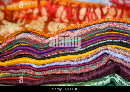 Chiudere orizzontale di vari colorati sari di seta ordinatamente ripiegati in una pila. Foto Stock