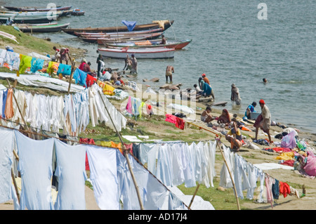 Ritratto orizzontale di indiani 'dhobi wallahs' lavabiancheria vicino al Kedar Ghat nell'acqua santa del fiume Gange Foto Stock