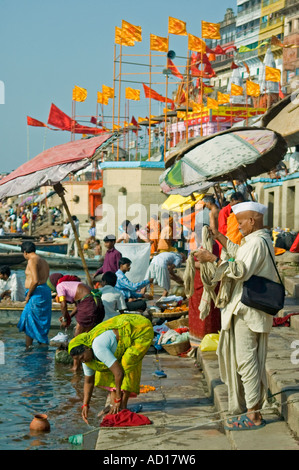 Verticale ampia angolazione di un gruppo di Indiani su Dasashvamedha Ghat lungo il corso del fiume Gange al mattino presto sun. Foto Stock