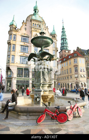 Città libera biciclette parcheggiate da una fontana in Copenhagen Foto Stock