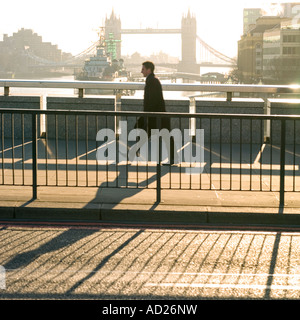 Andare al lavoro la mattina presto a chi lavora in ufficio camminando sul Ponte di Londra Foto Stock