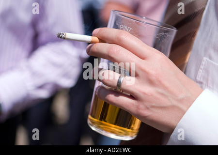 Immagine ravvicinata del giovane imprenditore gustando un drink e una sigaretta a pranzo nella città di Londra Foto Stock