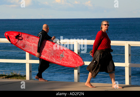 Uomo anziano con tavola da surf Bronte e donna Tamarama Sydney Australia Foto Stock