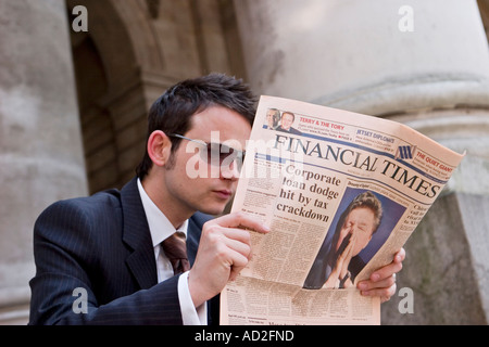 Giovane imprenditore letture Financial Times nella città di Londra Foto Stock