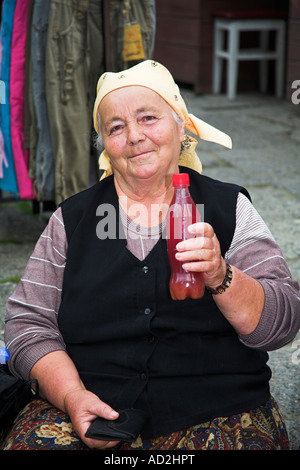 Old Lady in posa, tenendo la bottiglia di plastica di succo, Sovata, Transilvania, Romania Foto Stock