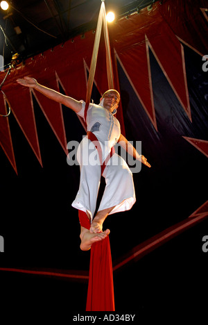 Circus acrobat performer tangled in drappi rossi Foto Stock