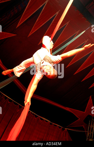 Circus acrobat performer tangled in drappi rossi Foto Stock