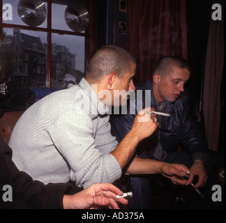 Due giovani uomini fumare cannabis giunti in un caffè di Amsterdam. Foto Stock