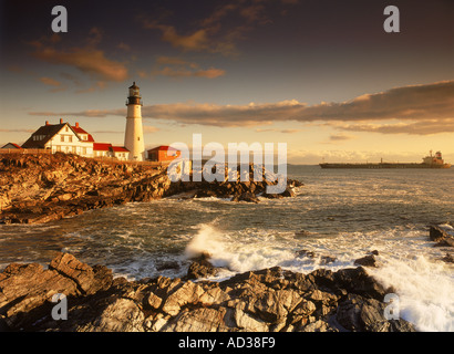 Nave passando Portland Head Lighthouse sulla costa del Maine all'alba Foto Stock