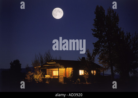 Luna piena di monte in log cabin in Wyoming Foto Stock