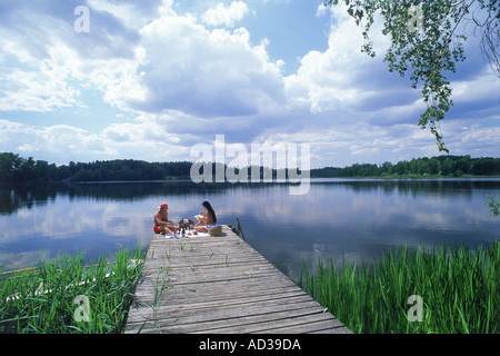 Giovane avente picnic sul lago dal molo Yxtaholm in Svezia Foto Stock