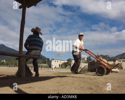 La gente parlare sulla periferia di un campo di calcio vicino al mercato principale Foto Stock