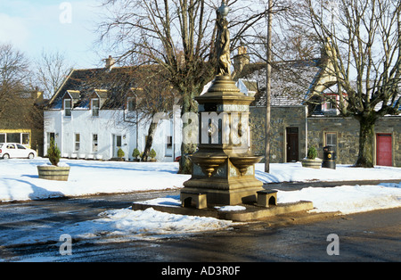 TOMINTOUL MORAY SCOZIA UK Febbraio un ornato fontanella in coperta di neve nel centro del paese circondata da edifici storici Foto Stock