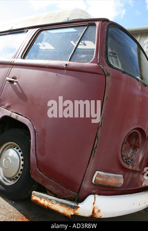 Picchiati vecchia Volkswagen camper parcheggiato a vecchi edifici di garage, Pembrokeshire, Galles del Sud Foto Stock