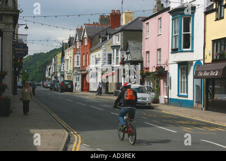 Ciclista solitario in Castle Street a Beaumaris, tranquilla e inizio di domenica mattina, Isola di Anglesey, Galles del Nord Foto Stock