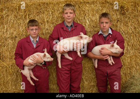 Gli alunni alla scuola Brymore di tecnologia rurale con suinetti Somerset England Regno Unito GB Foto Stock