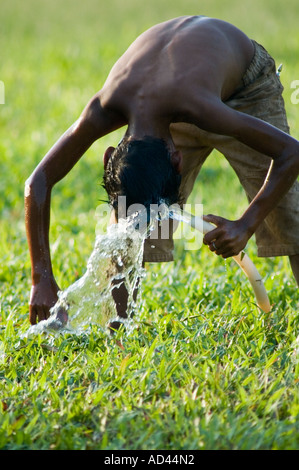 Ragazzo il lavaggio dei capelli, Cambogia Foto Stock