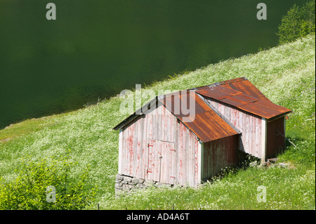 Vecchio capannone di legno accanto a Esesfjorden vicino a Balestrand Sogn og Fjordane Norvegia Foto Stock