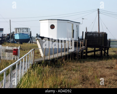 West Mersea house boats in appoggio sul fango erbosa appartamenti sulla riva del canale Strood vicino al fiume Blackwater estuary Foto Stock