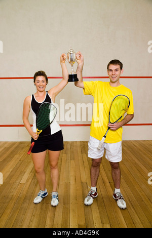Due campi da squash compagni di squadra tenendo un trofeo Foto Stock